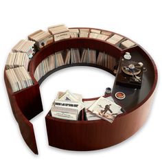 a circular book shelf with books on top and an open cd case in the middle