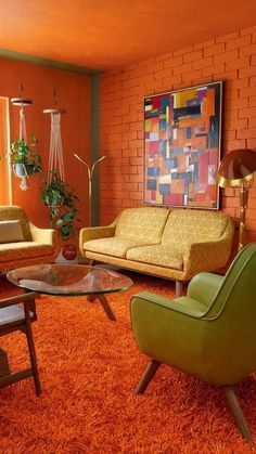 a living room filled with furniture and orange carpeted flooring next to a brick wall