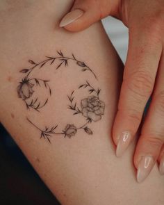 a woman's stomach with flowers and leaves on it, in the shape of a circle