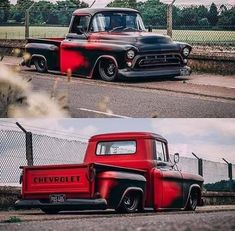 an old red and black truck parked on the side of a road next to a fence