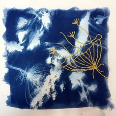 a blue and white painting with yellow thread on it