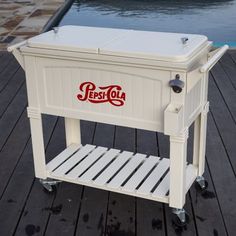 a white cooler sitting on top of a wooden dock