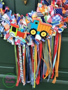 a wreath made out of colorful ribbons with a truck on it's front door