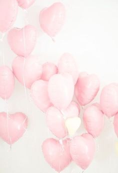 pink heart shaped balloons floating in the air