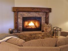 a living room with a fire place and couches in front of the fireplace,