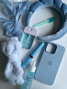 an assortment of personal care items laid out on a white counter top with blue accessories