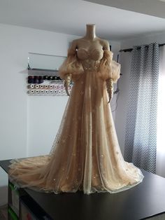 a dress is displayed on a table in front of a window