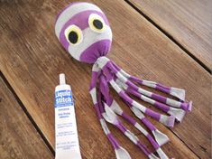 an octopus stuffed animal next to a tube of toothpaste on a wooden table