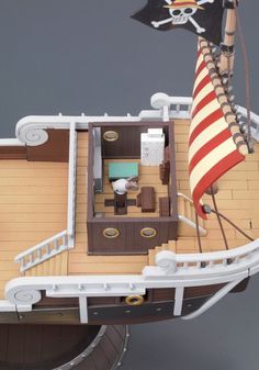 a toy boat with a pirate flag on it's mast and the top deck