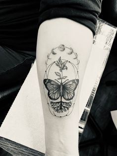 a woman's arm with a butterfly and flower tattoo on the left inner forearm