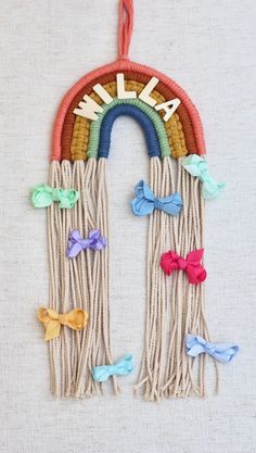 a wall hanging made out of yarn with bows