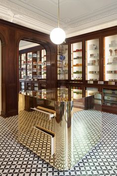 a large glass table in the middle of a room filled with shelves and bookshelves