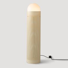 a lamp that is on top of a white surface with a cord attached to it