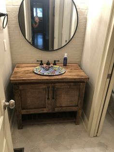 a bathroom sink with a mirror above it and a wooden cabinet in front of it