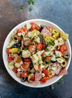 a white bowl filled with lots of different types of food on top of a table