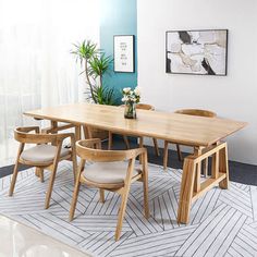 a dining room table with chairs and a plant in the corner on top of it