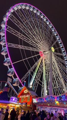 the ferris wheel is lit up at night