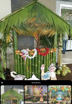 a house made out of bamboo sticks with flowers and decorations around it on the table