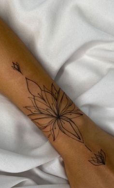 a woman's foot with a tattoo on it and a white sheet in the background