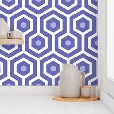 a kitchen counter with two vases on it and a wallpaper pattern in the background