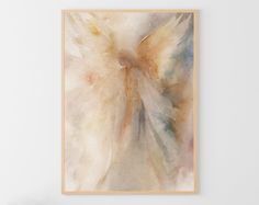 an angel painting hangs on the wall above a chair in a room with white walls