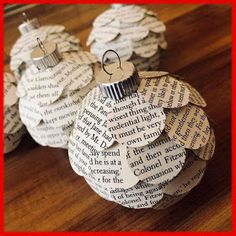 three ornament made out of book pages sitting on top of a wooden table