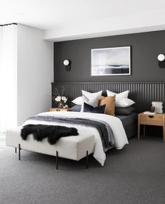 a bedroom with gray walls and white bedding