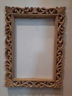 an ornate wooden frame hanging on the wall