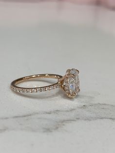 a close up of a diamond ring on a marble surface