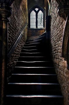 the stairs lead up to an arched window