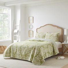 a bedroom with white walls and green bedding