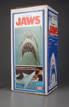 a box that has an image of a shark on it and the words jawss written in red