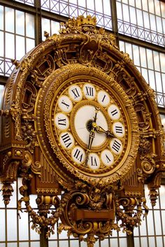 an ornate gold clock with roman numerals on it