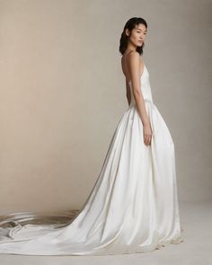 a woman in a white wedding dress posing for the camera