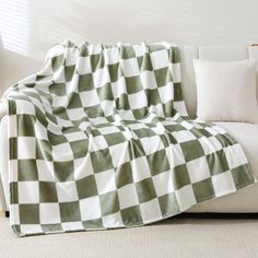 a green and white checkered blanket sitting on top of a couch