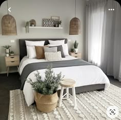 a bedroom with a large bed and two planters on the nightstands