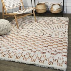 a white and brown area rug in a living room next to a wooden chair with a pillow