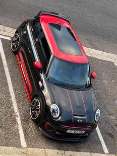 a small black and red car parked in a parking lot