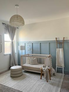 a baby's room with a white crib and blue walls