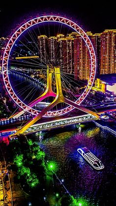 the ferris wheel is lit up at night