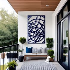 an outdoor area with a bench, potted plants and a painting on the wall