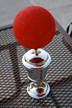 a red ball sitting on top of a metal table