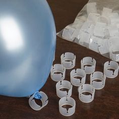 there are many pieces of plastic that have been placed on the table next to a balloon