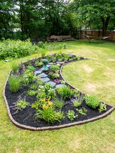 a garden with lots of plants and flowers in it's center, surrounded by green grass