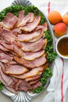 a platter filled with meat and vegetables next to oranges