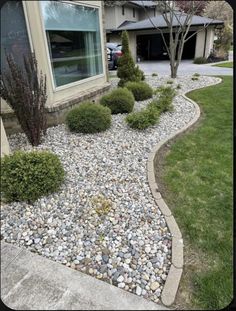 a house with rocks and grass in front of the window, next to a driveway