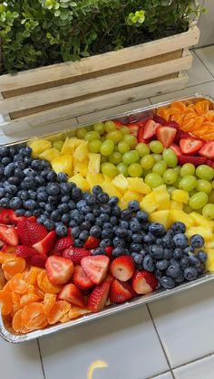 a tray filled with fruit sitting on top of a tiled floor