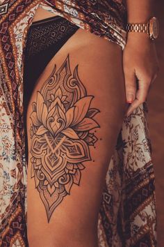 a close up of a person's thigh with a tattoo on the leg and an intricate design