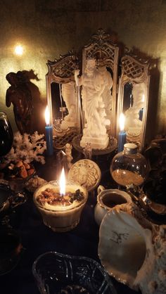 candles are lit in front of an ornate mirror