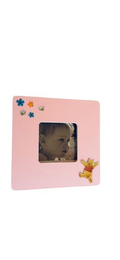 a pink photo frame with a baby's face in the center and flowers on it